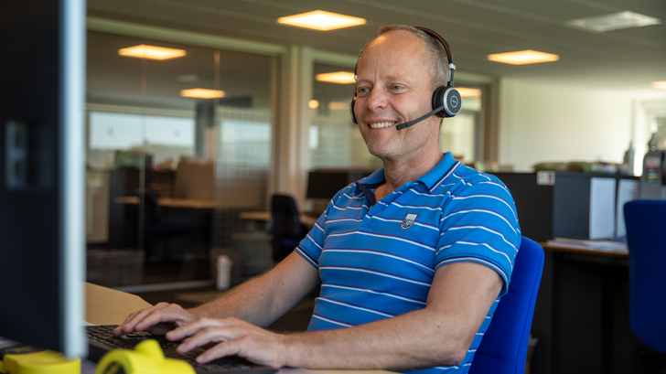 Insatech employee wearing a over-ear headset, ready to speak with customers. 