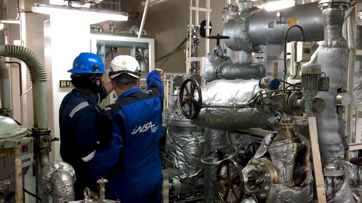 Two Insatech service technicians working in a machine room 