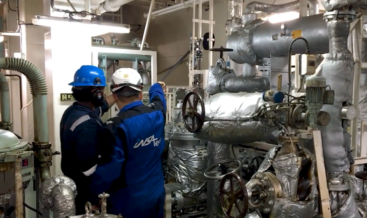 Two Insatech service technicians working in a machine room 